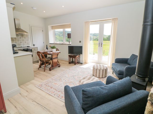 A living room with a dining area and view of the garden at The Plucking Shed in Stockport