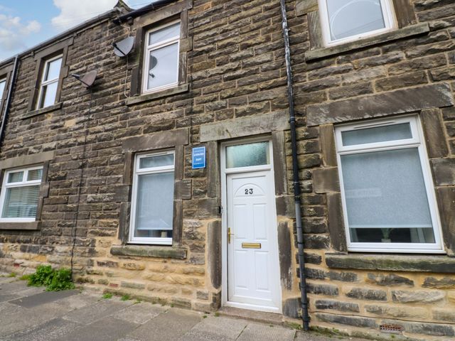 An exterior view of a house with stone walls and a door at Amblers Rest in Amble
