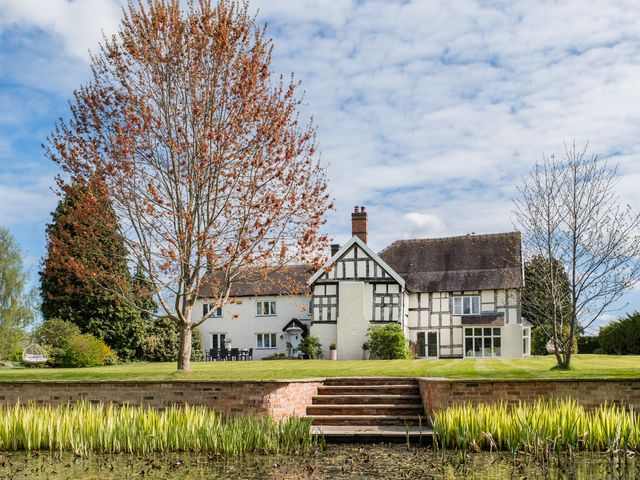 A house surrounded by a garden with trees and a water feature at Hall O'Coole in Broomhall nearn Wrenbury