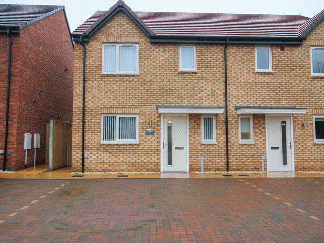 A brick house with entrance doors and parking area at 10 The Colliery Telford