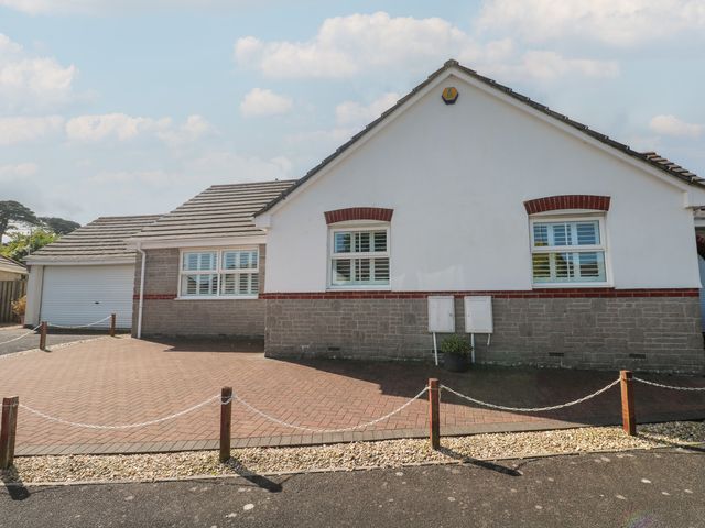 A house with a paved driveway and garage at Jaluna in Carbis Bay
