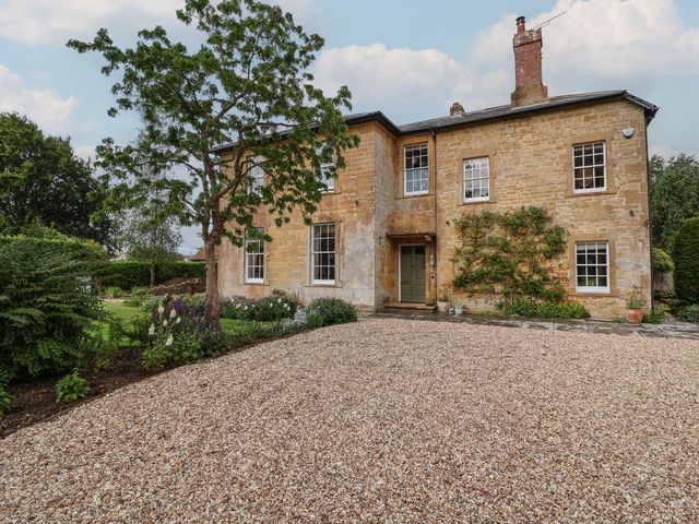A house with windows and a door in a garden at The Old Vicarage in Merriott