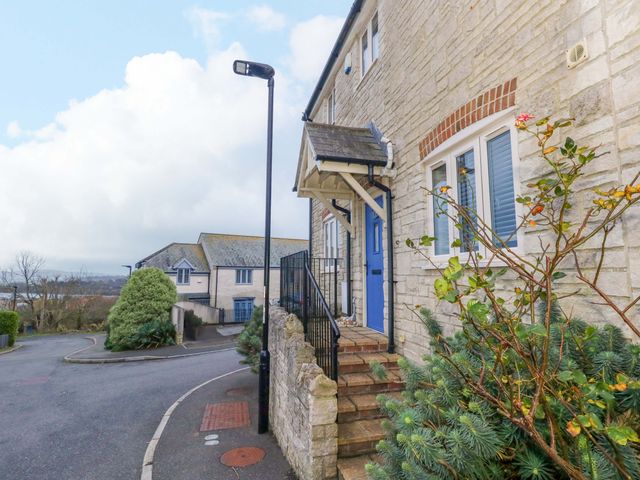 An exterior view of a house with steps and a blue door at Corner Cottage in Preston