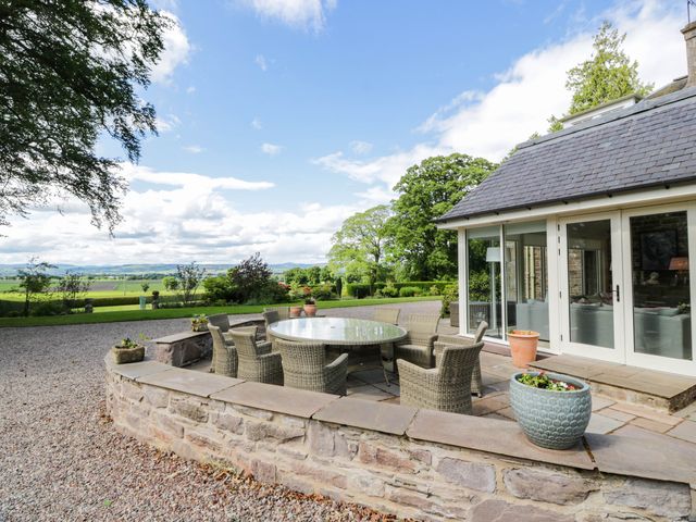 An outdoor seating area with a table and chairs at Eagle Glen Manor House in Blairgowrie