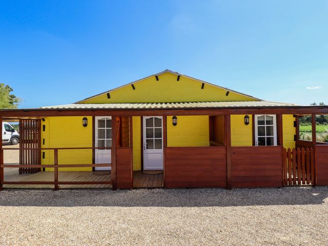 A yellow building with wooden deck and white doors at Lancaster, New York near Coningsby