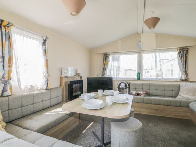 A living room with a table set for dining at Tower View Number 34 Pevensey Bay