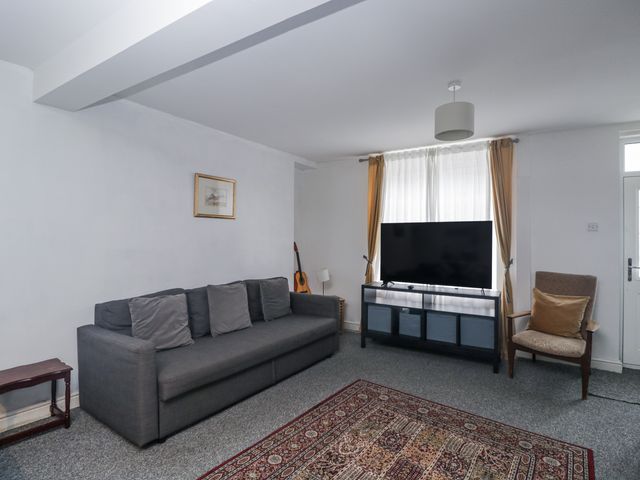 A living room with a sofa and television at Maindy Lodge