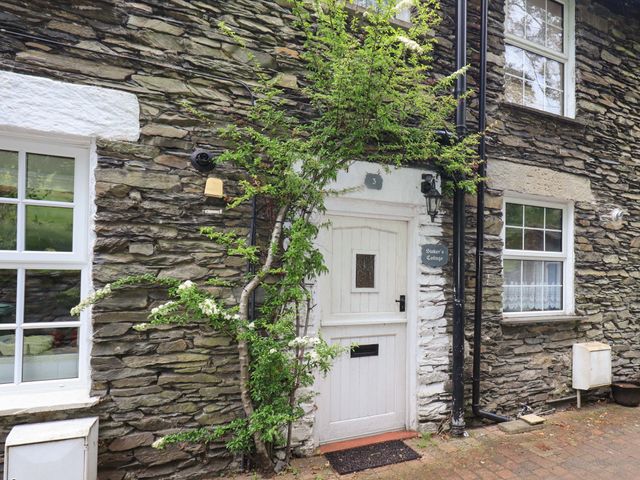 An entrance with stone wall and door at Stoker’s Cottage Bowness-On-Windermere