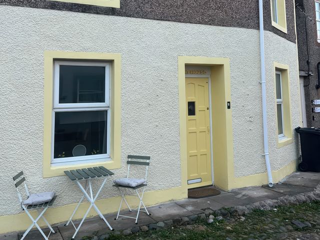 A doorway and window with outdoor seating at Sun House in Allonby