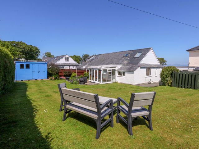 A garden with a patio set and a shed at Swn Y Don