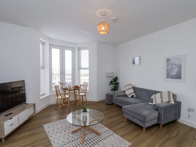 A living room with a sofa and dining area at Apartment 2 in Redcar