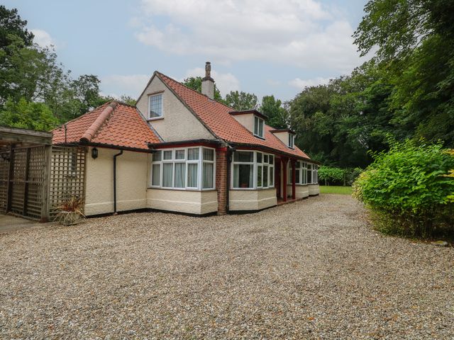 A house with a driveway and garden at The Anchorage in Hoveton & Wroxham