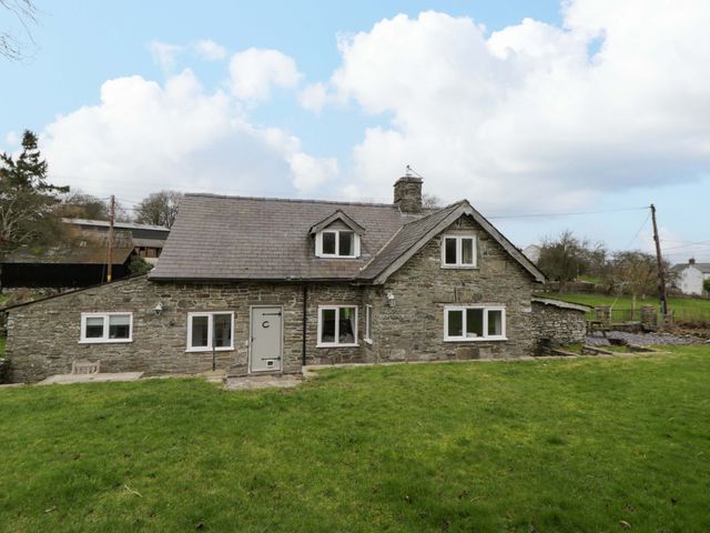 A house with windows and a door surrounded by grass at The Old Shop in Builth Wells