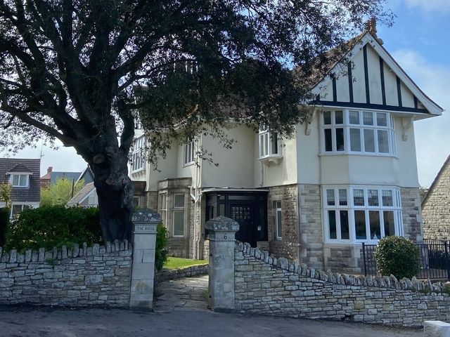 A house with a garden and stone wall at Purbeck Vista in Swanage