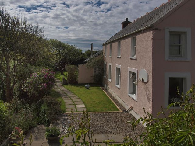 A house with a garden and pathway at The Pink House Nine Wells near Solva