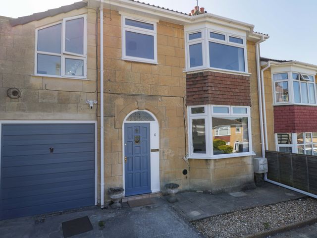 A house with a blue front door and garage at 6 Newbridge Gardens in Bath