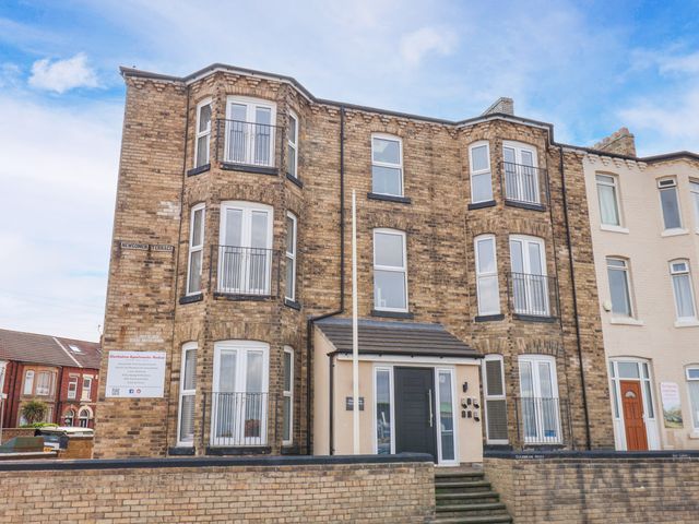 An apartment building with balconies and a sign at Apartment 4 (1 bed) Redcar