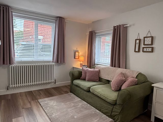 A living room with a green sofa and lamp at 96 Church Street in Guisborough