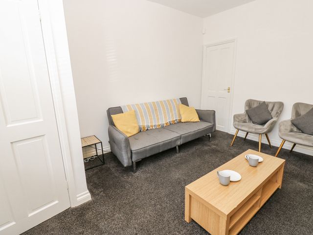 A living room with a sofa and chairs at Cumberland House in Workington