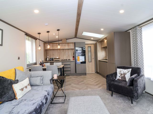 A living room with a sofa and dining table at Hazelnut Lodge in Chipping Norton