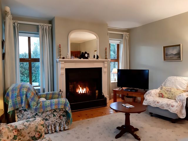 A living room with a fireplace and television at Moynish Mor Mulranny MULRANNY