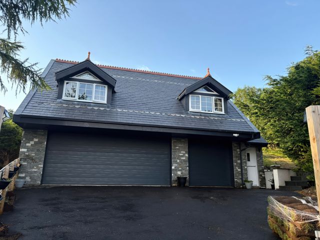 A house with garage doors and windows at Skerry Vore in Llandudno Junction