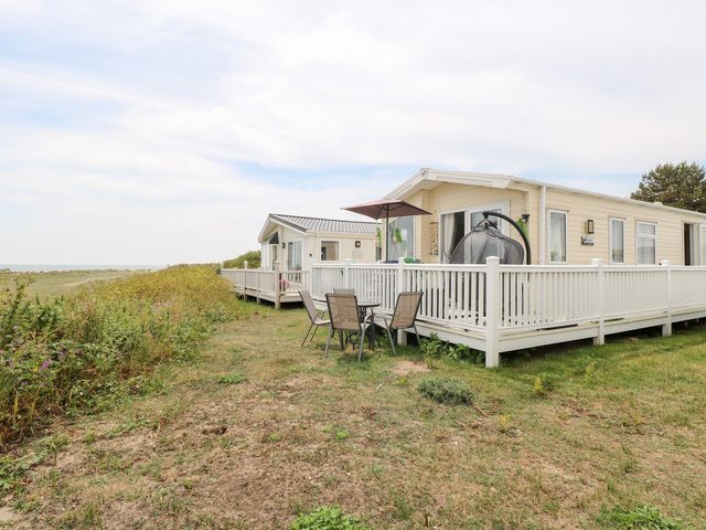 A house with a deck, table, and chairs at No. 2 - Seaview, Kessingland