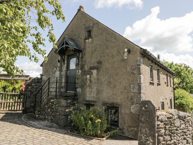 An exterior view of a house with a pathway and stone wall at Treacle in Carnforth