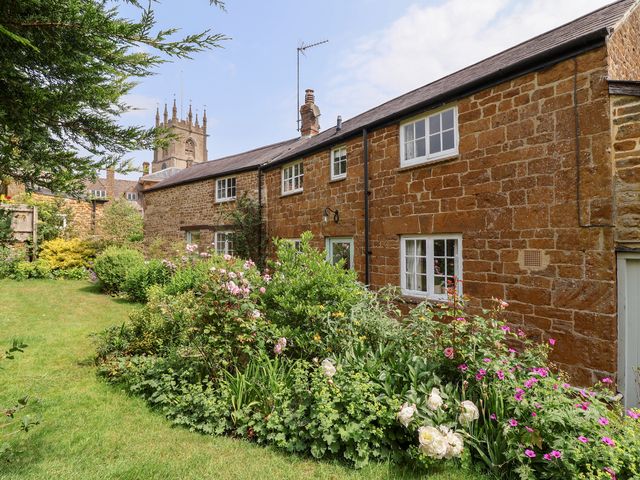 A house with a garden and flowers at Magdalen Cottage in Hook Norton