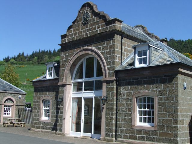 A stone building with large windows and a clock at The ClockTower in Perth