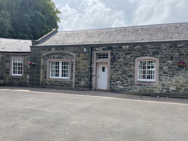 An exterior view of a stone building with windows and door at Coach House 4 Perth