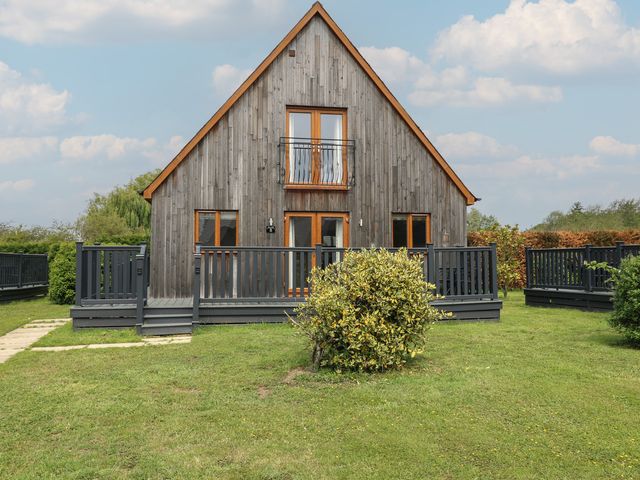 A house with a wooden exterior and decking at Lodge 8 in Brigg