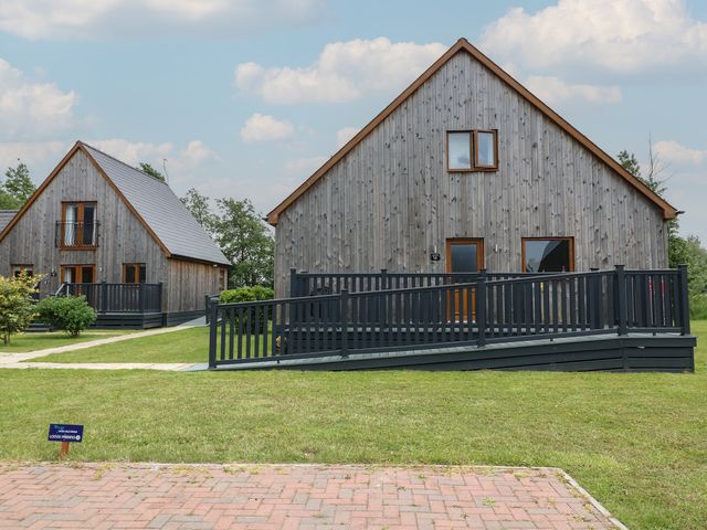 Two wooden houses with ramps and grass area at Lodge 14 in Brigg
