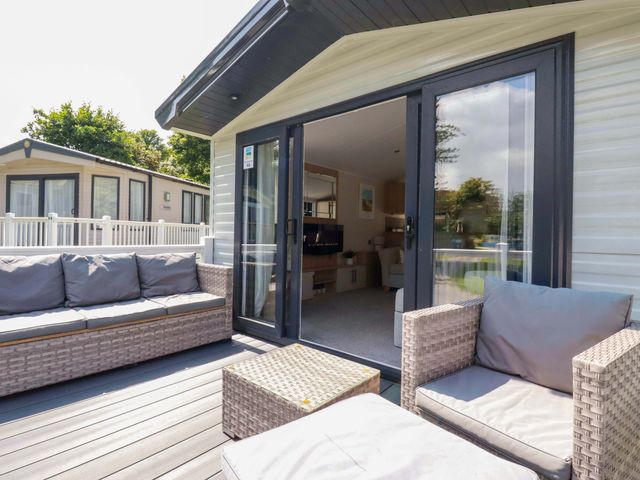 An outdoor patio area with a couch and table at Meadow 46 in Newquay