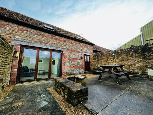An outdoor area with a table and chairs at Barn Cottage in Frome