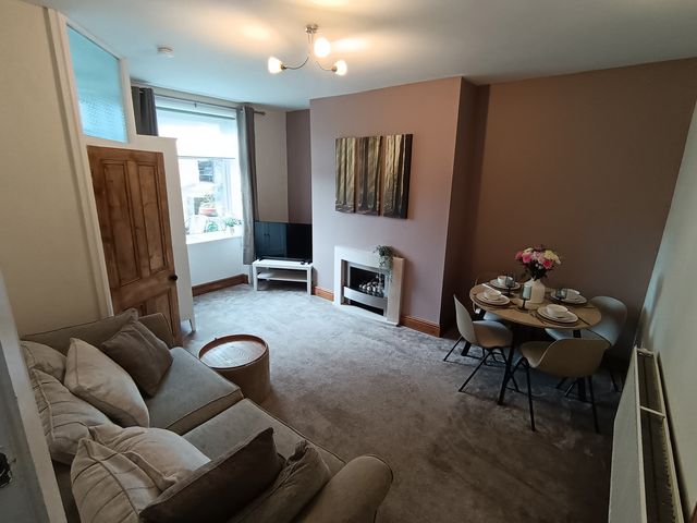 A living room with a sofa and dining table at 14 Lindon Street