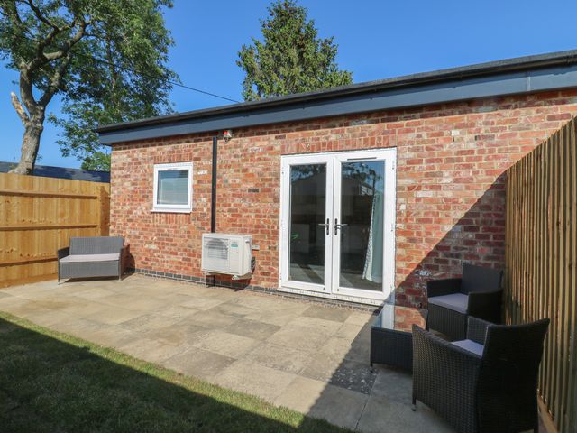 A garden area with seating and glass doors at Annex studio 2 Northampton