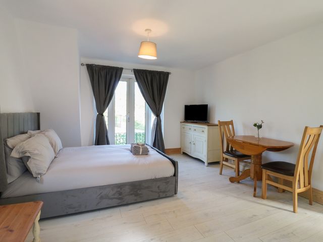 A bedroom with a bed and dining area at Sunflower Northampton