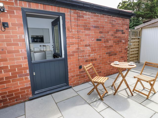 An outdoor area with a door, table and chairs at Little Birchinlea in Glossop