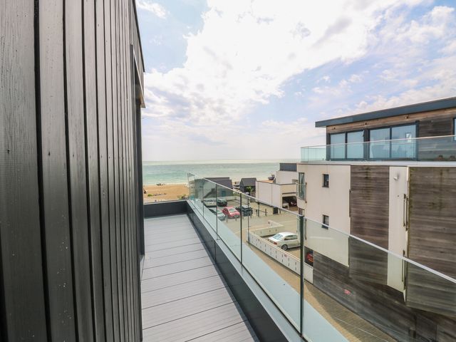 A balcony overlooking the ocean and beach at Flat 4, Hythe
