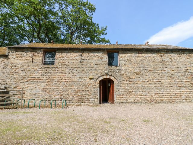 Exterior view of a stone building with a door and window at East Barn Bunkhouse