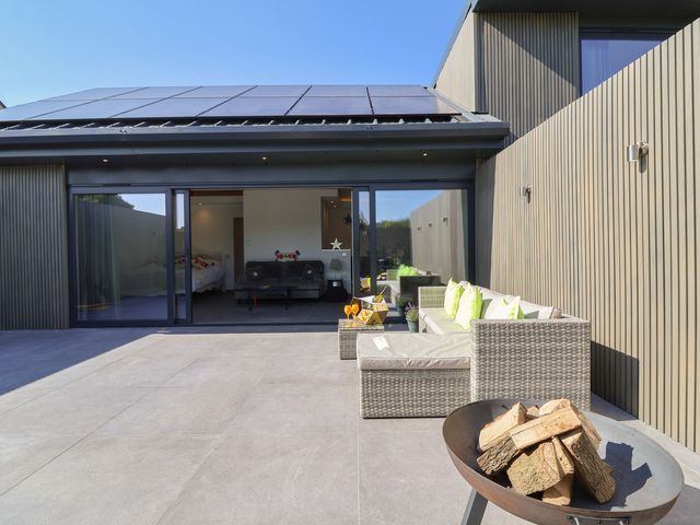 An outdoor patio with seating and a fire pit at Noflash Malpal in Bristol