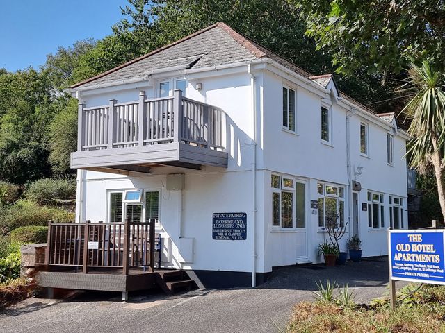 An exterior view of the Old Hotel Apartments with a balcony and plants at Tater-Du in Porthcurno near Land’s End