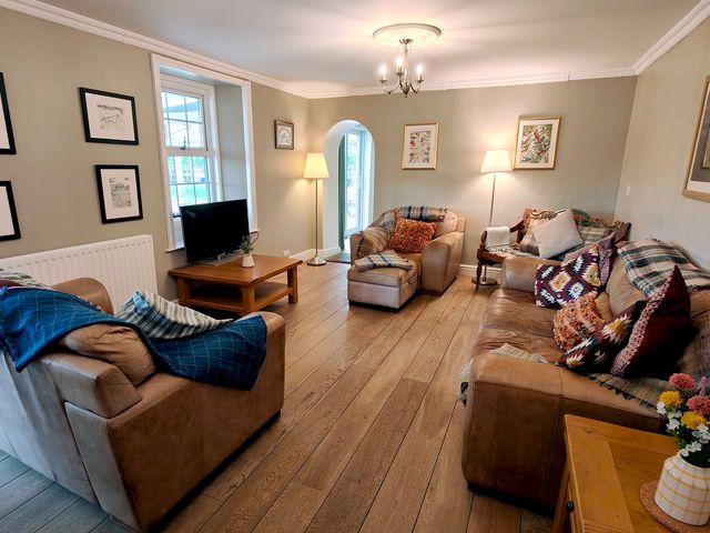 A living room with sofas and a television at Bush Nook House in Brampton
