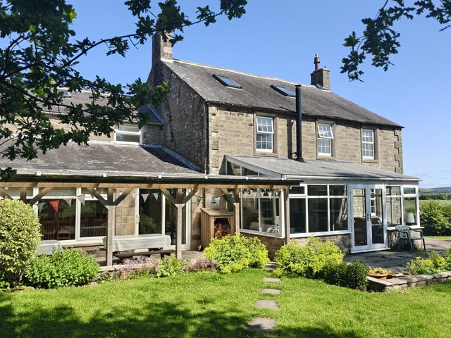 A house with a conservatory and garden at Bush Nook House in Brampton, Cumbria