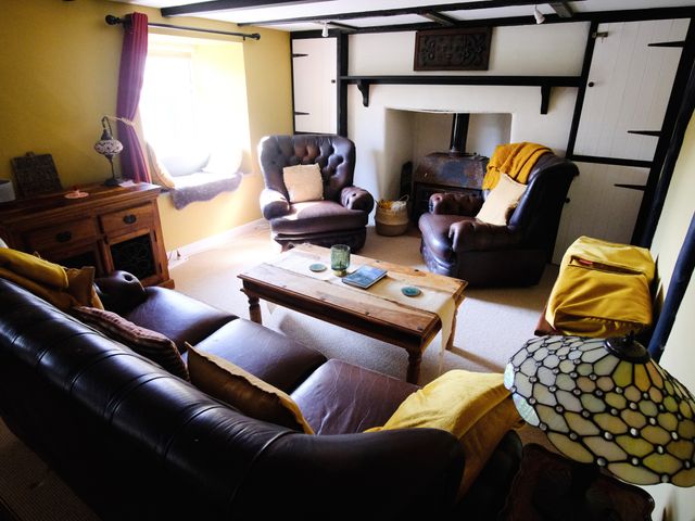 A living room with sofas and a coffee table at Sunnybrae Cottage in Tintagel