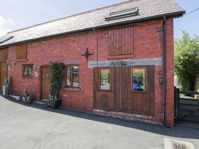 A brick exterior with windows and a door at Owl Cottage in Llangollen