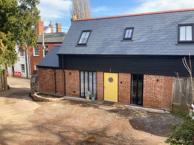 A building with a yellow door and windows at Jams in Lympstone