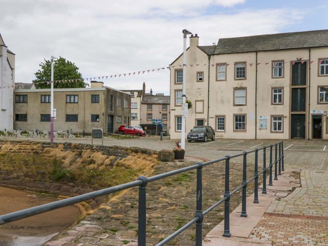 An outdoor area with buildings and parked cars at Duncan Square in Whitehaven