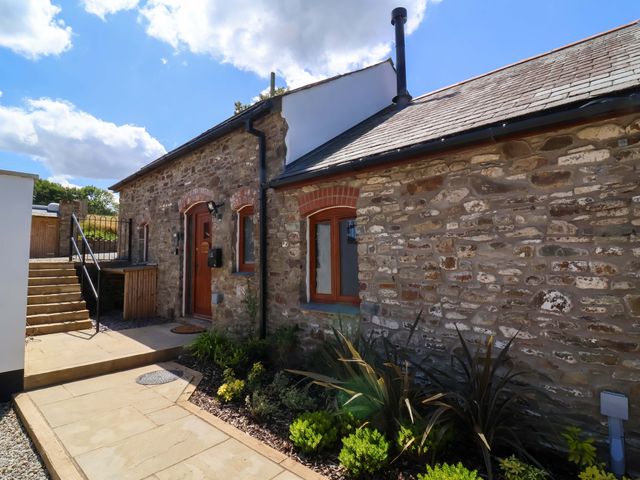 An outdoor view of a cottage with stone walls and garden at Hedgehog Highway Parkham